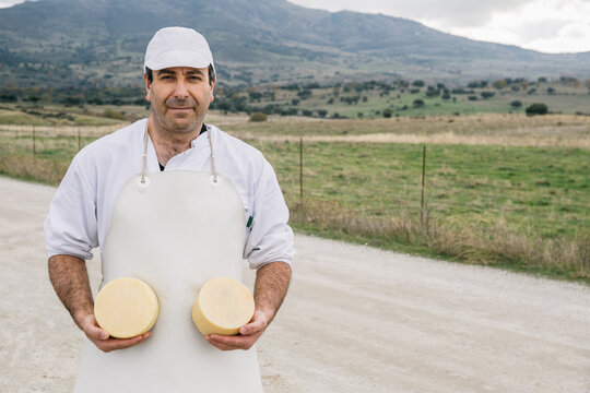 Cheesemaker posing on rural background