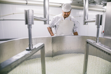 Man watching after machine making cheese