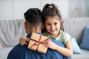 Happy Father's Day. Cute Little Girl Hugging Dad And Holding Gift Box