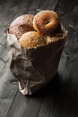 Vari tipi di pane caratteristico e tipico dentro una busta in carta, isolati su un tavolo di legno © alex.pin