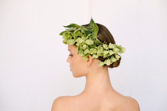 The back of a cute girl whose head is decorated with flowers