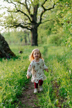 Child hopping on path in forest