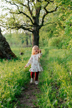 Child hopping on path in forest