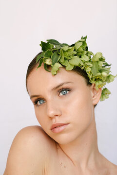 Sensual portrait of a young blue-eye's girl with flowers covering her head
