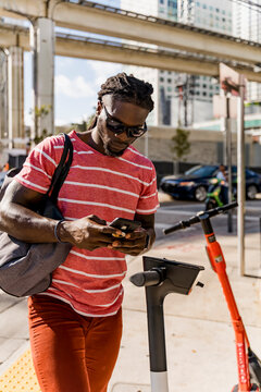 Black man unlocking an electric scooter to move faster