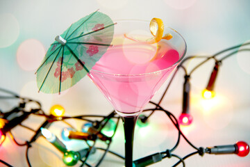 cosmopolitan cocktail with umbrella and colourful party lights