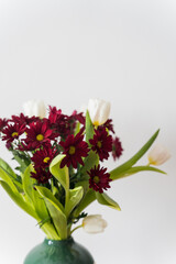 Bouquet of tulips and chrysanthemums in a vase on a white background. High-quality photo