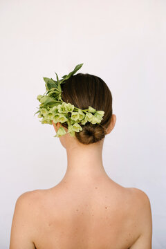 The back of a cute girl whose head is decorated with flowers