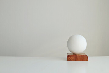 Stylish interior mockup with white geometric shape of a ball on a  wooden stand, copy space