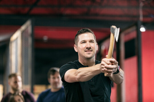 Man Aiming Hatchet At Throwing Target