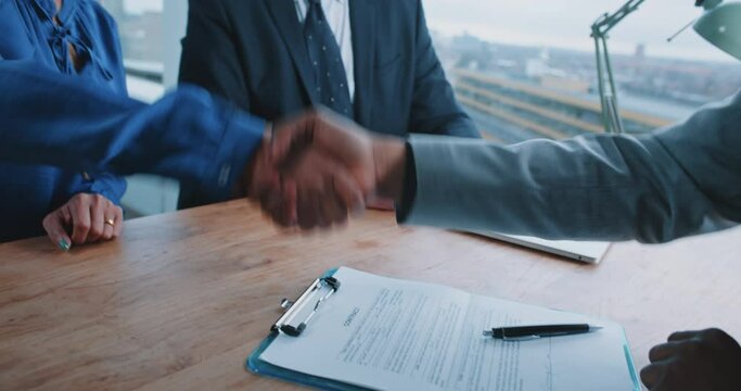Close up of an African man signing contract and shaking hands with the recruiters
