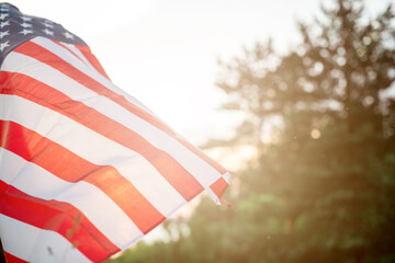 American flag flutters against the backdrop of the setting sun in nature. Veterans Day Flag of the United States of America, Independence Day