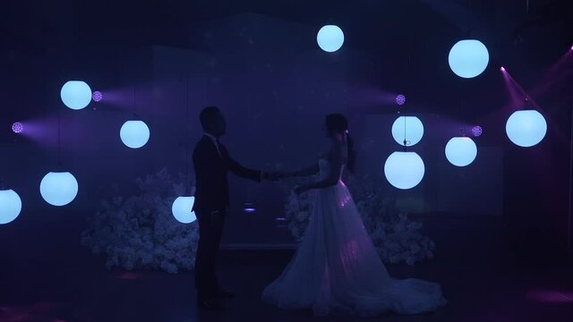 The couples first dance in a wonderful atmosphere, around glowing balls and a dark background