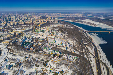 Beautiful winter top view of the Kiev-Pechersk Lavra. Many churches in the snow. Beautiful panorama of Kiev in the afternoon.