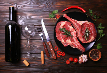 Wine bottle with beef steak with spices on wooden background