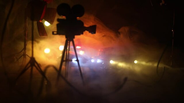 Action movie concept. Police cars and miniature movie set on dark toned background with fog. Police car chasing a car at night. Scene of crime accident. Selective focus