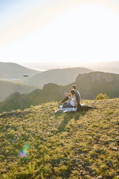 father and son fly and shoot video on a quadrocopter over the mountains at sunset