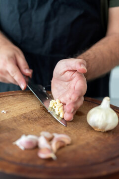 Closeup of a man cutting garlic in the kitchen