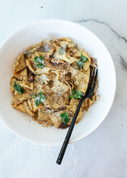 Bowl of pasta with butter browned garlic, shaved parmesan and parsley