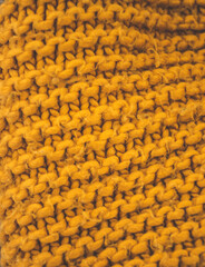 Fototapeta premium Closeup of woolen knitted textured fabric. Orange knitting pattern.