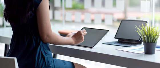 Image of a businesswoman working on a tablet at a coffee shop.