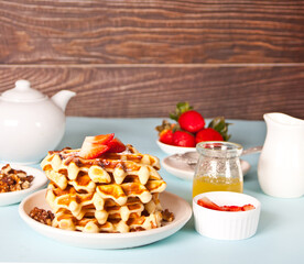 Freshly homemade baked waffles with strawberries and honey.
