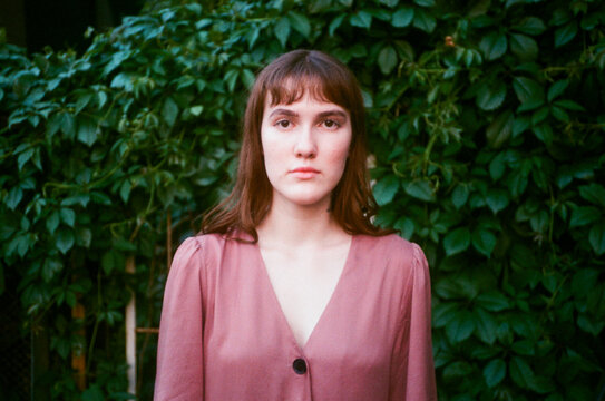 Girl's portrait in front of a green plant