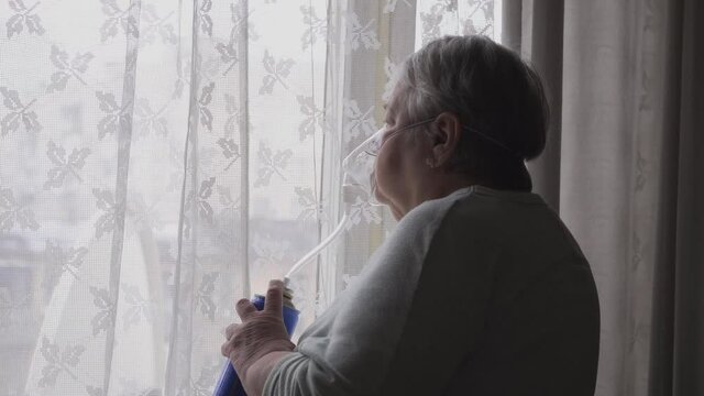 Senior Woman put on and breathing with an oxygen mask