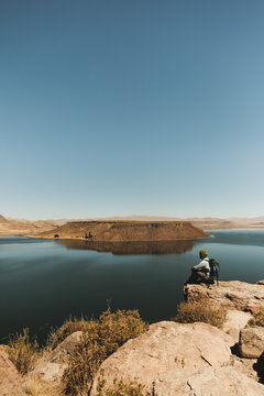 traveler sitting admiring the beauty of lake Umayo in Puno - Peru