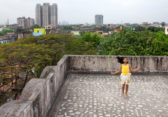 Teenage Girls Doing Exercise With A Jumping Rope In A Roof Top Of Urban Area