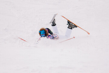 Girl in bright suit beautifully falls on skis