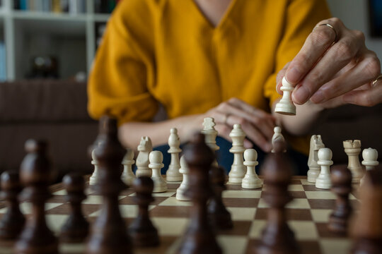 Asian woman playing chess at home