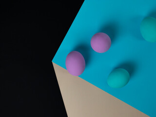 on a paper cube Easter eggs of pink and blue color, eggs in falling, optical illusion, Easter, concept, copy space