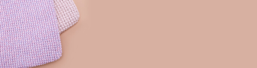 Banner with pink knitted handmade bags or other homemade things on beige background. Eco-friendly shopping. Zero waste lifestyle. Top view, copy space