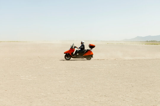Man Driving a scooter in the desert