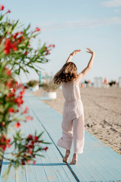 Young woman dancing on the beach in summer