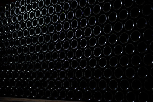 Wine bottles in wine cellar, row of glass bottles