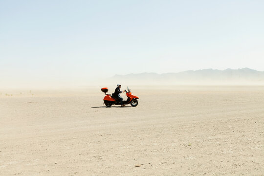 Man Driving a scooter in the desert