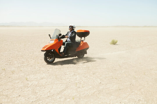 Man Driving a scooter in the desert