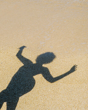 Shadow of a dancing girl in the sand