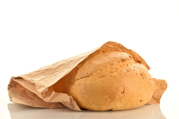 One loaf of delicious white bread in a paper bag, close-up, isolated on white.