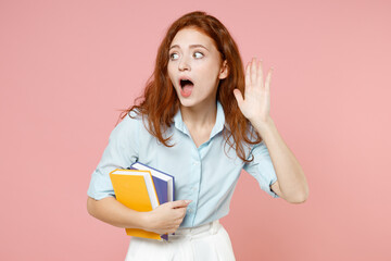 Young curious nosy redhead student woman in blue shirt hold book try to hear you overhear listening...