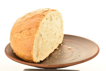 One half of white bread on a clay plate, close-up, isolated on white.