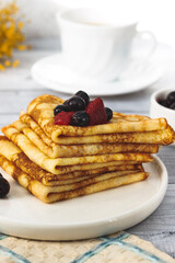 Thin pancakes with with Raspberry and Currant on Plate. Russian traditional dessert for Shrovetide celebration (maslenitsa). French crepes