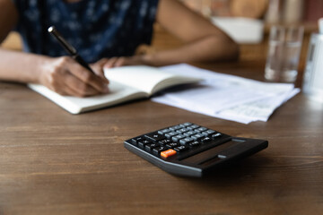 Close up cropped view of millennial black female sit by desk work with financial papers bills...
