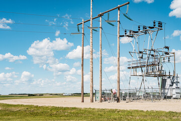 electricity pylons on wheat field in sunny day