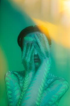 Woman with body art covering face