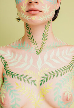Unrecognizable model breast with leaves pattern on skin