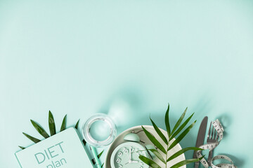 Composition with cutlery, measuring tape, food diary and alarm clock on color background. Diet...