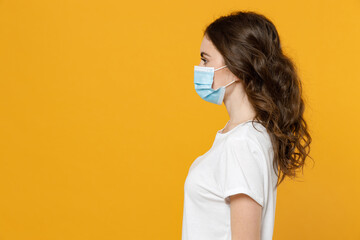 Side view of young woman in white basic casual t-shirt in sterile face mask from coronavirus virus...